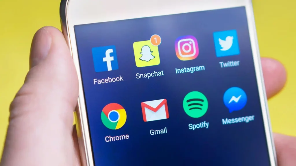 Um celular com as redes sociais: Facebook, Snapchat, Instagram, Twitter, Chrome, Gmail, Spotify e Messenger
