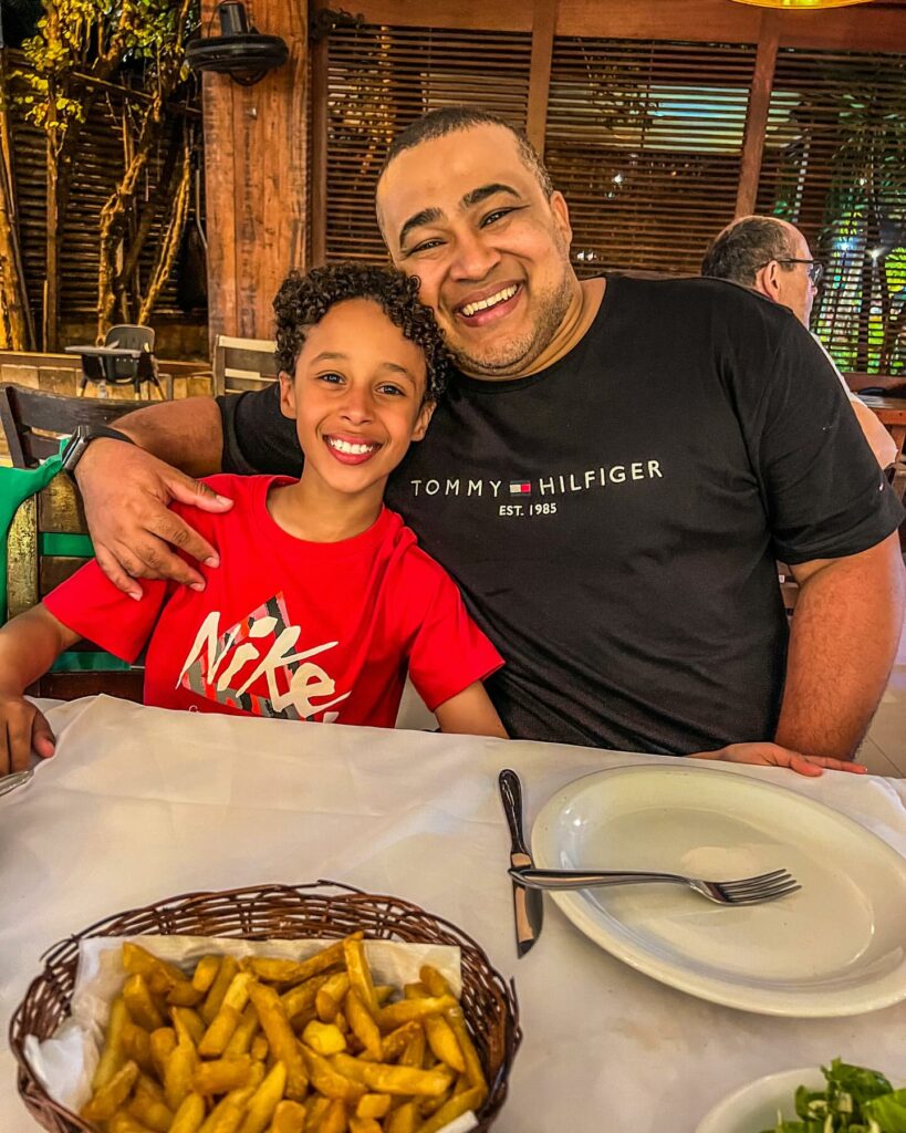Thiago Barboza junto com seu filho em um restaurante.